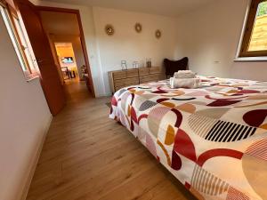 a bedroom with a bed with a colorful comforter at L’impasse - Au bord de l’eau in Épagne-Épagnette