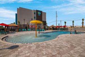 a pool with a yellow umbrella in front of a building at Tru By Hilton Destin in Destin