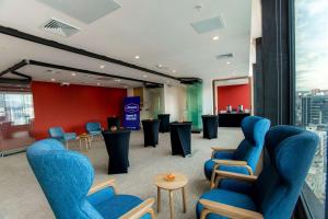 una sala de espera con sillas y mesas azules en Hampton By Hilton Quito La Carolina Park, en Quito