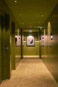 波尔图Arts Hotel Porto, Tapestry Collection By Hilton的走廊上设有绿色的墙壁和墙上的绘画作品