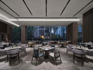 een restaurant met tafels en stoelen en een groot raam bij Doubletree By Hilton Rugao in Rugao