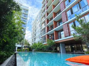 a swimming pool in front of a building at Tierra Residences in Bangkok +58 photos
