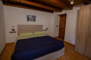 1 dormitorio con 1 cama grande y cabecero de madera en rainbow home, en Arvier