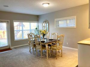 comedor con mesa de madera y sillas en Mahogany Escape - Your Calgary Oasis, en Calgary