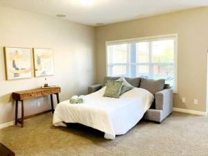 a bedroom with a bed and a table and a couch at Mahogany Escape - Your Calgary Oasis in Calgary