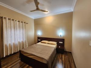 Schlafzimmer mit einem Bett und einem Deckenventilator in der Unterkunft The Royal Oasis Goa in Majorda