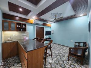 a room with a kitchen with a counter and chairs at The Royal Oasis Goa in Majorda