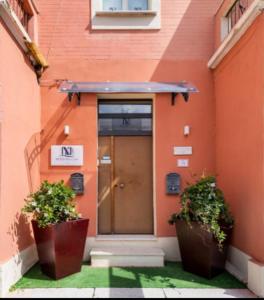 雷焦卡拉布里亞的住宿－B&B De Nava Suite，一座建筑,前面有门和两棵植物