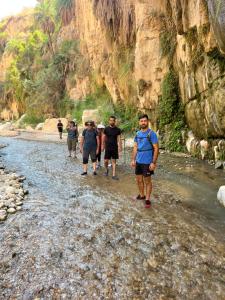 a group of people walking down a rocky river at the old house in Kerak