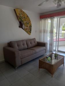 een woonkamer met een bruine bank en een tafel bij Tropical Optimal Tropicana Sur in Sosúa