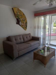 a living room with a brown couch and a table at Tropical Optimal Tropicana Sur in Sosúa