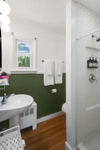 La salle de bains verte est pourvue d'un lavabo et de toilettes. dans l'établissement Birches Motel, à Saratoga Springs