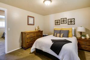 a bedroom with a bed and a wooden dresser at Updated Ranch Apartment with Deck - 9 Mi to Downtown in Taylorsville