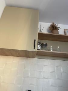 uma cozinha com um armário e piso em azulejo branco em Garsoniera Luca em Drobeta-Turnu Severin