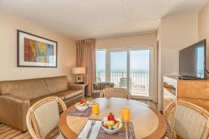 a living room with a table and a couch at Reges Oceanfront Resort in Wildwood Crest