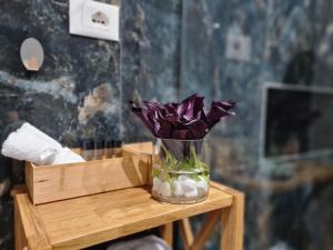 都拉斯的住宿－Rosemarine Villas，木桌上带紫色花的玻璃花瓶