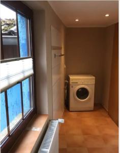 lavadero con lavadora y ventana en Blaues Haus Neu Reddevitz, en Lancken-Granitz