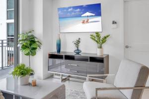 una sala de estar con un centro de entretenimiento con TV en Centrally Located 2 BED in the Heart of Downtown With Free Parkin en Miami