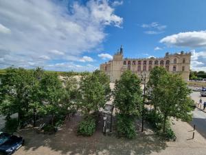 un edificio con un montón de árboles delante de él en Face château St Germain en Laye, appartement 4 à 6 personnes, 23 min de Paris Champs-Elysées, en Saint-Germain-en-Laye