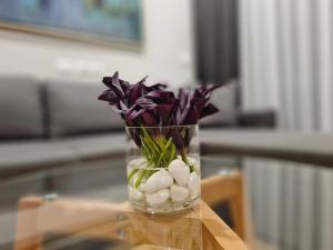 un vase rempli de roches et de fleurs violettes sur une table dans l'établissement Rosemarine Villas, à Durrës