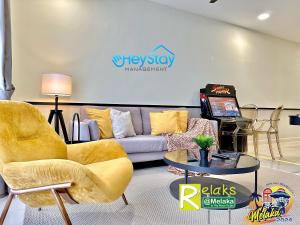 sala de estar con sofá y mesa en The Apple Residence By Heystay Management, en Melaka