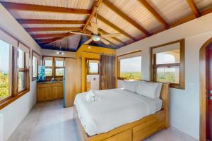 una camera da letto con un letto grande e finestre di Beachfront Villa Island Pearl Gold Standard Certified a Caye Caulker Altre 37 foto