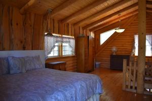 a bedroom with a bed in a wooden cabin at Sky Cabin in Ruidoso