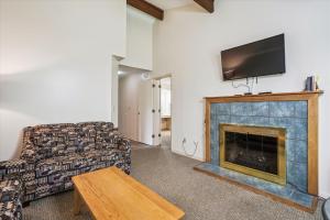 uma sala de estar com um sofá e uma lareira em Cedarbrook Deluxe Two Bedroom Suite with outdoor heated pool 10506 em Killington