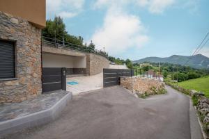 a house with a driveway with a garage at Apartamentos Spa Las Caldas y Spa El Balneario in Oviedo