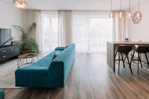 a living room with a blue couch and a table at REVON Business apartment Senec in Senec