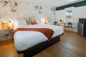 een slaapkamer met een groot bed met bloemenbehang bij Birches Motel in Saratoga Springs
