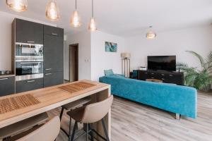 a living room with a blue couch and a table at REVON Business apartment Senec in Senec