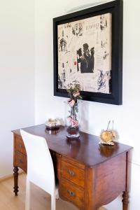 een houten bureau met een witte stoel en een foto aan de muur bij B&B RED WINE COUNTRY HOUSE in Castel San Pietro Terme