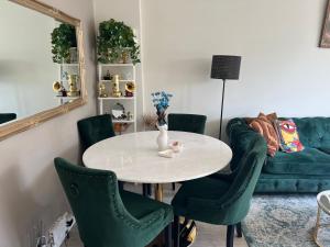 奧斯陸的住宿－Central Comfort Room in heart of Oslo, Majorstuen，客厅配有桌子和绿色椅子