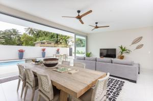 a dining room with a table and a couch at Villa Varia in Rarotonga