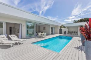 a house with a swimming pool and a deck at Villa Varia in Rarotonga