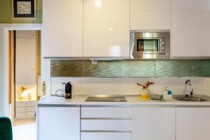 een keuken met witte kasten en een magnetron bij Aile Granada - Hostatel in Granada +113 foto's