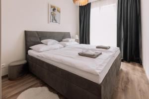 1 dormitorio con 1 cama grande con sábanas blancas en REVON Business apartment Senec, en Senec