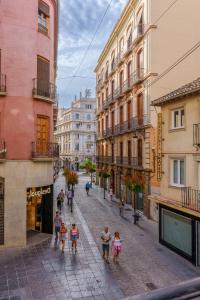 een groep mensen die door een straat met gebouwen loopt bij Aile Granada - Hostatel in Granada