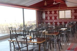 a room filled with wooden tables and chairs at Yara camp in Wadi Rum +135 photos