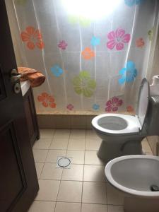 a bathroom with a toilet and a shower curtain with flowers at Talabay apartment 20109 in Al Burj