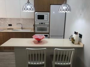 a kitchen with a counter with two chairs and a microwave at ENMAYO 2021 - Dos alojamientos in Córdoba