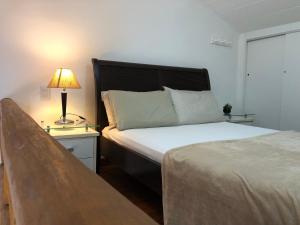 1 dormitorio con cama y mesita de noche con lámpara en Loft encantador em Praia do Forte próximo à Vila., en Praia do Forte