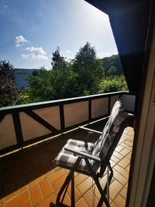 einen Stuhl auf einem Balkon mit Blick auf das Wasser in der Unterkunft Charmantes Ferienhaus Casa Ella mit Balkon in Siegen