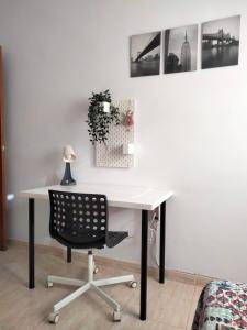 a white desk with a black chair and pictures on the wall at Agaete Fray in Agaete