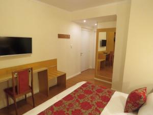 a hotel room with a bed and a desk and a television at Grand Hotel in Reconquista