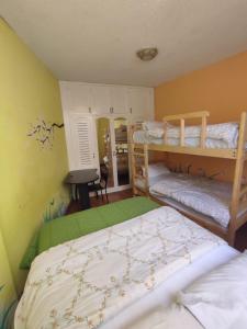 a bedroom with two bunk beds and a mirror at Mayra's Apartments and Spanish School in Baños