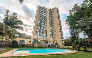 un edificio con piscina en frente de un edificio en KimOcean La Ballito Apartment, en Ballito