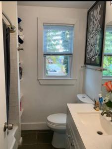 a bathroom with a toilet and a sink and a window at Cozy 2/1.5 Getaway in Lily Ponds in Washington, D.C.