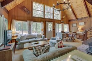 a living room with a couch and a tv at Rustic, Cozy Cabin with Easy Ski and Beach Access! in Bridgton